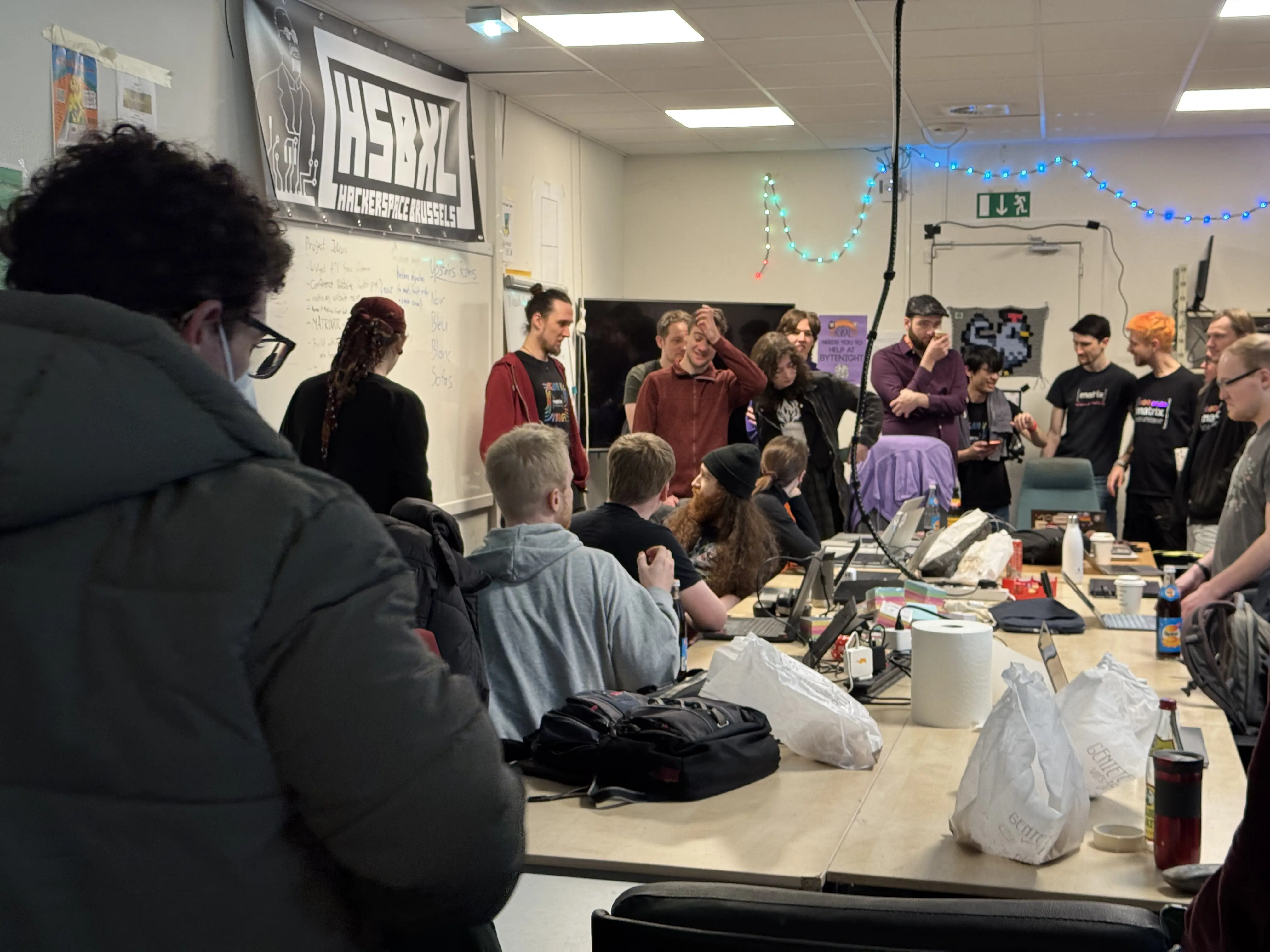 A picture of people gathered around a whiteboard